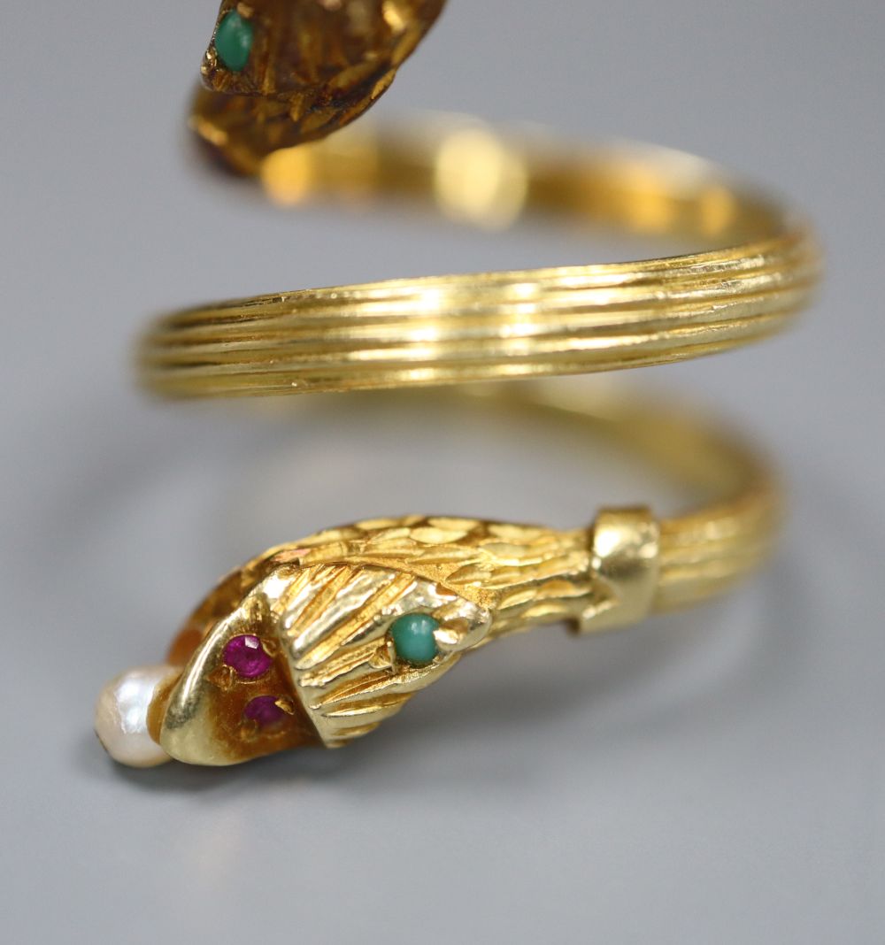 A Georgian style reeded yellow metal and gem set twin headed serpent ring,